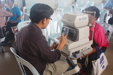 Elderly folks are given a follow-up eye check before being given their glasses.